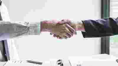two hands shaking hands representing customer care in a VMS